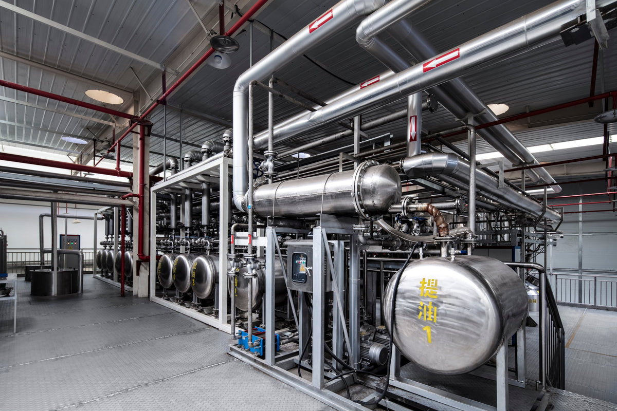 Produktionshalle mit Edelstahltanks, Rohrleitungen und Schaltschrank